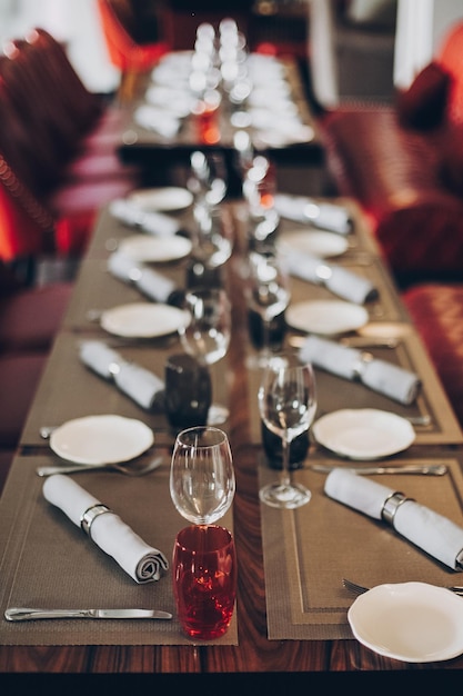 Роскошная красная сервировка стола на стойке регистрации в ресторане для винной вечеринки или свадьбы Стильные бокалы для винных тарелок с столовыми приборами из салфеток на столе Современное красное кейтеринговое обслуживание Рождественский пир