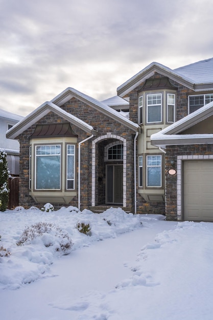 Luxury residential house in snow on winter cloudy day