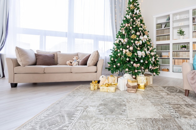 Luxury rich expensive apartment interior in light colors. Stylish contemporary minimalistic design. Full of sun light. A lot of space decorated with Christmas tree