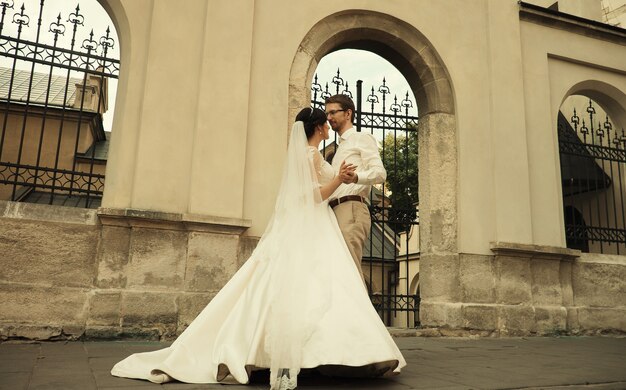 Luxury romantic happy bride and groom celebrating marriage on the background of old sunny city