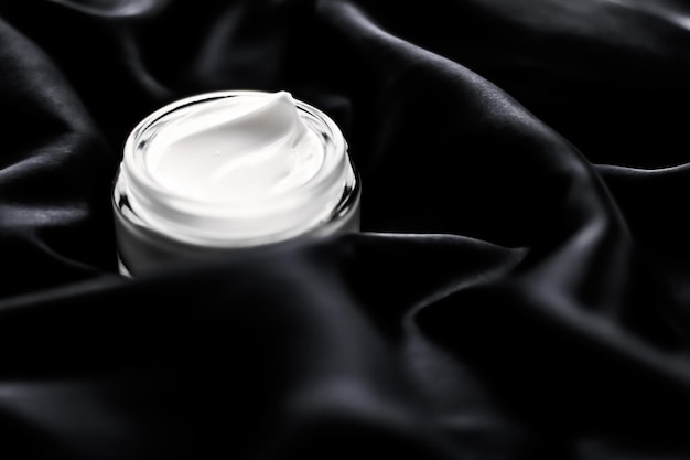 Luxury sensitive skincare moisturizing face cream on black silk background