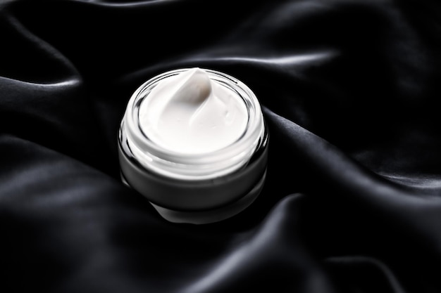 Luxury sensitive skincare moisturizing face cream on black silk background