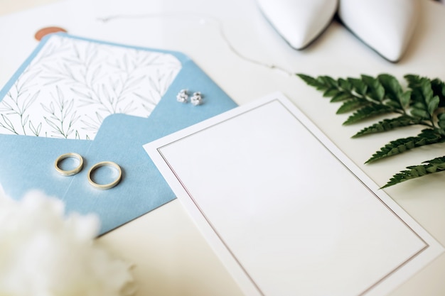 Luxury set of wedding invitations, wedding rings, elegant accessories of the bride on a white background.