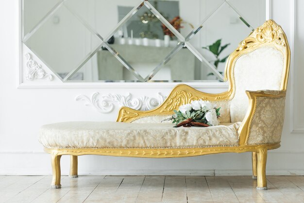 Photo luxury vintage sofa with gold near the mirror, beautiful classic interior