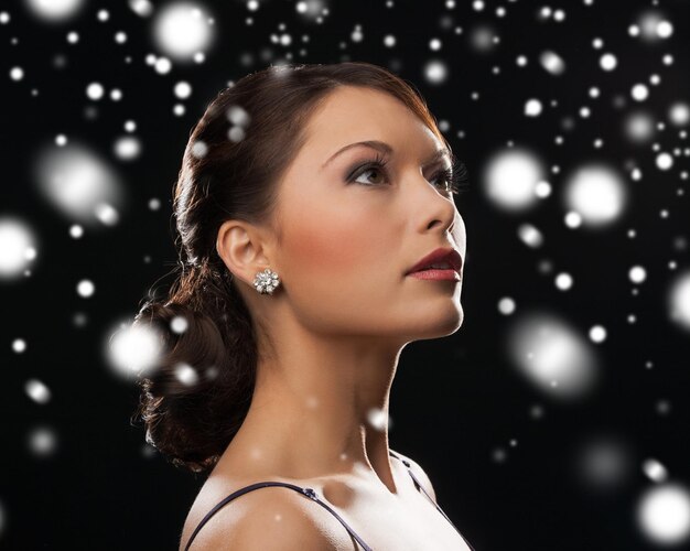 luxury, vip, nightlife, party, christmas, x-mas, new year's eve concept - beautiful woman in evening dress wearing diamond earrings