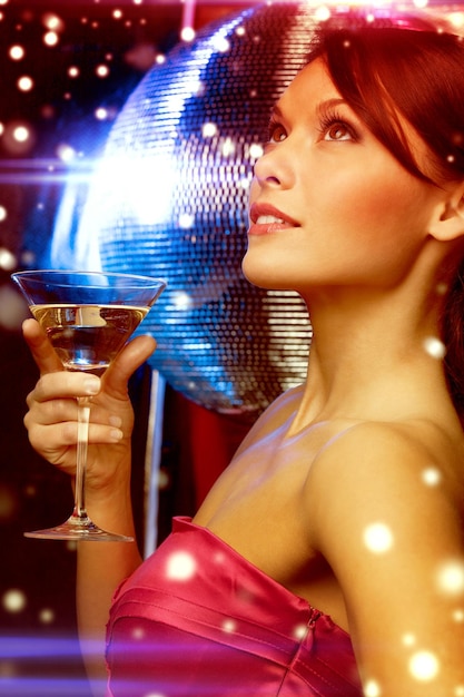 Фото Роскошь, vip, ночная жизнь, вечеринка, рождество, рождество, новогодняя концепция - красивая женщина в вечернем платье с коктейлем и диско-шаром