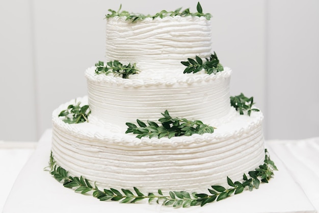 Torta bianca a più livelli per matrimoni di lusso decorata con foto di fiori di notte sullo sfondo delle luci