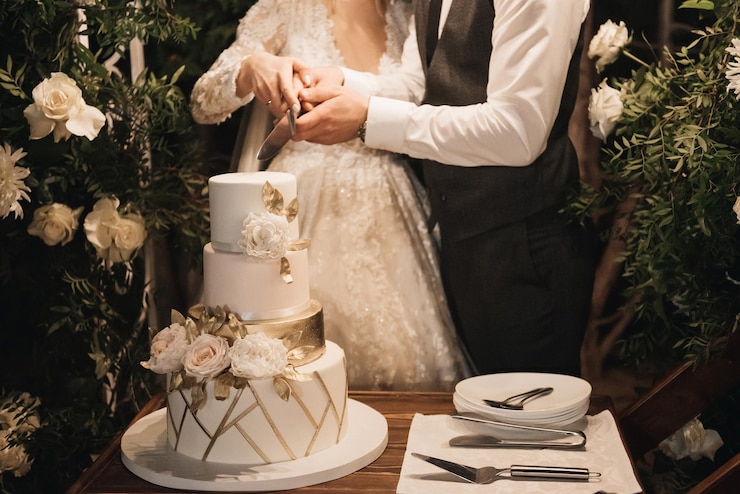 Photo luxury wedding tiered white cake decorated with flowers photo at night on the background of lights