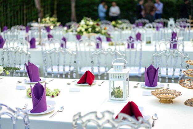 豪華な白-紫-赤のディナーテーブルは、庭にクリスタルの椅子がセットされています。