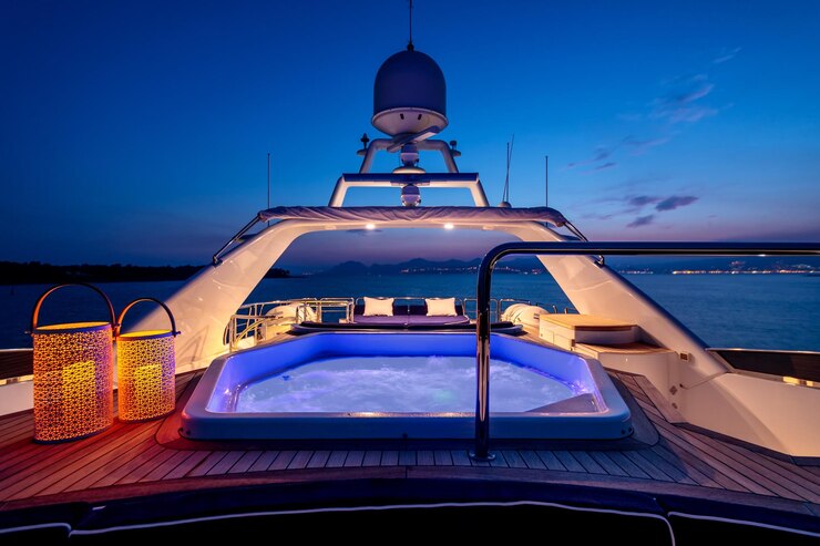 Photo luxury yacht with lights and a jacuzzi sailing in the sea at night