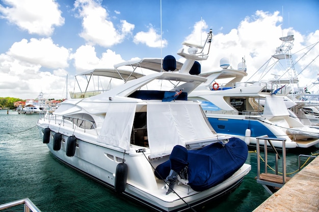 Luxury yachts docked in the port in bay at sunny day with\
clouds on blue sky in la romana, dominican republic