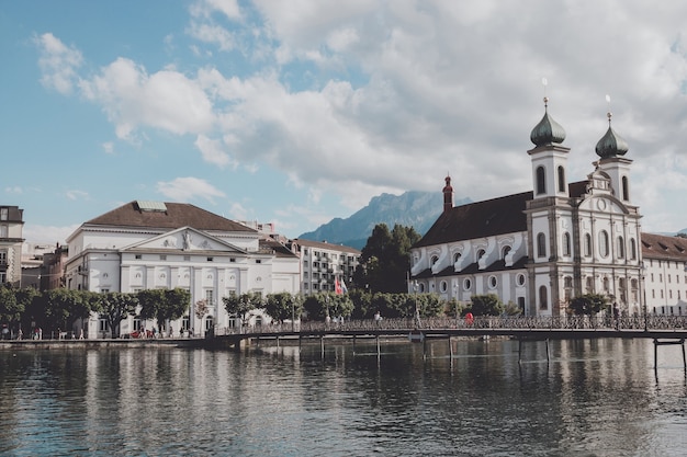 Luzern, Zwitserland - 3 juli 2017: Panoramisch uitzicht over de stad Luzern met jezuïetenkerk en rivier de Reuss. Dramatische lucht en zonnig zomerlandschap