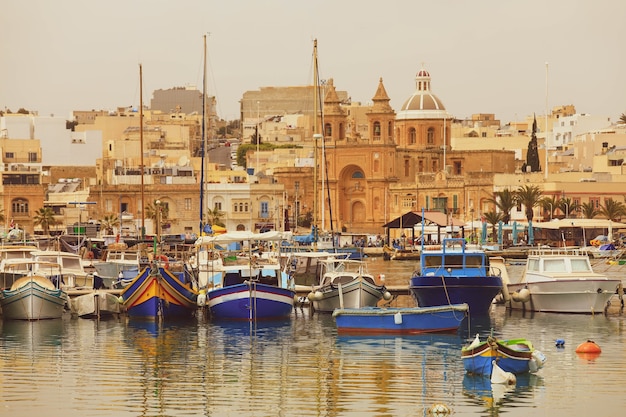 Luzzu traditional eyed colourful boats in the harbour of fishing village, Mediterranean Sea.