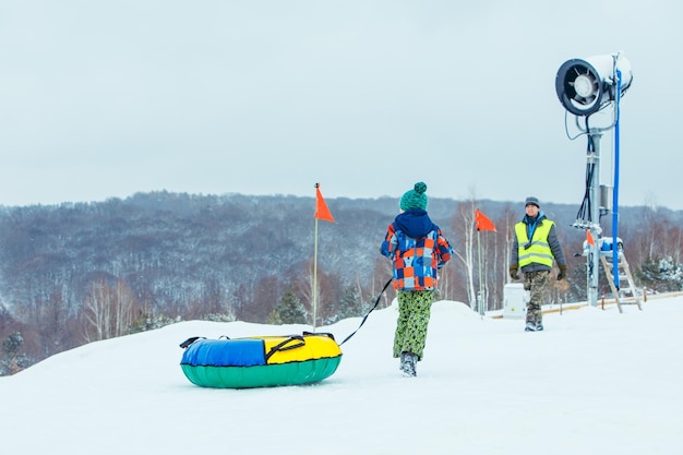 LVIV UKRAINE January 7 2019 children sliding snow tube down by snowed hill