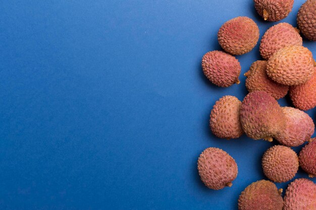Lychee fruit on color background Top view flat lay
