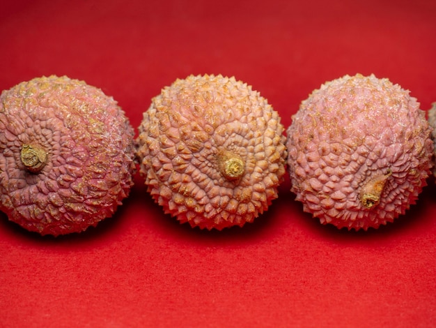 Lychee on the table Chinese plum on a red background Ripe fruit from Asia Delicious juicy product