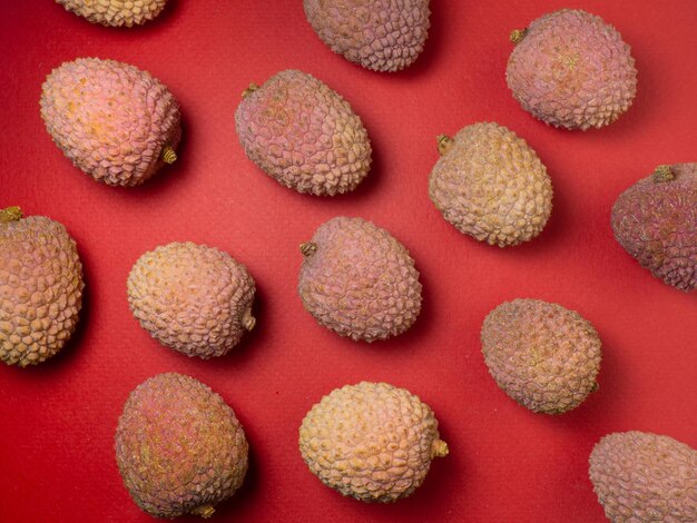 Lychee on the table Chinese plum on a red background Ripe fruit from Asia
