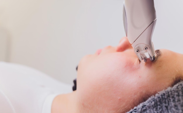 Photo lymphatic drainage massage lpg apparatus process therapist beautician makes a rejuvenating facial massage for the model in a beauty salon close up selective focus