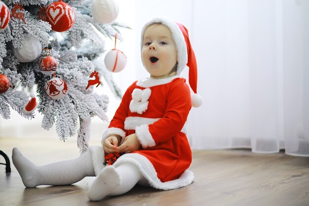 M Familievakantie Meisje schattig kind vrolijk humeur spelen in de buurt van kerstboom