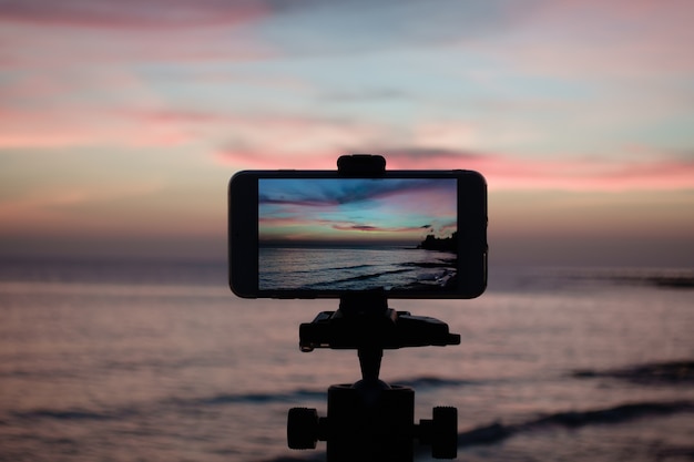 Maak een foto van de lucht vanaf een smartphone die op een statief is geplaatst