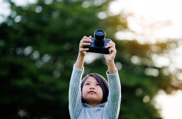 Maak foto's met een spiegelloze camera Klein meisje oefent weinig natuurfotografie