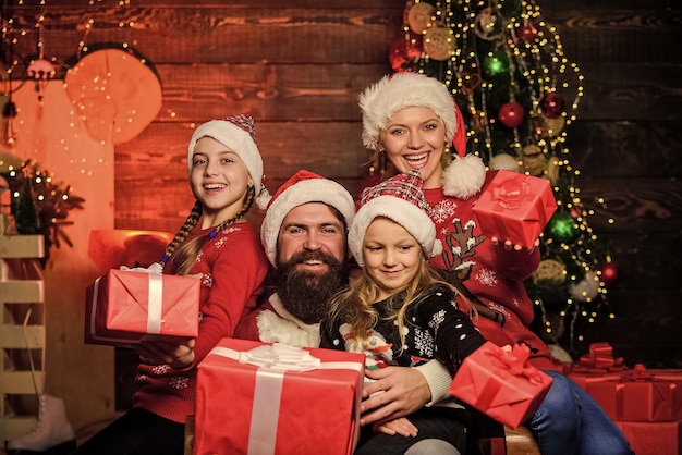 Maak je liefde gelukkig vrolijke moeder liefde kinderen santa vader bij versierde boom Gelukkige familie viert nieuwjaar en Kerstmis kleine meisjes met ouders openen kerstcadeaus van santa