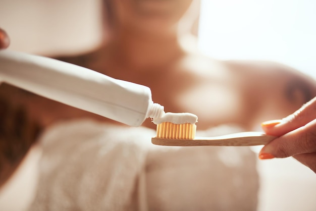 Maak je tandarts trots Bijgesneden opname van een vrouw die haar tanden poetst in de badkamer thuis