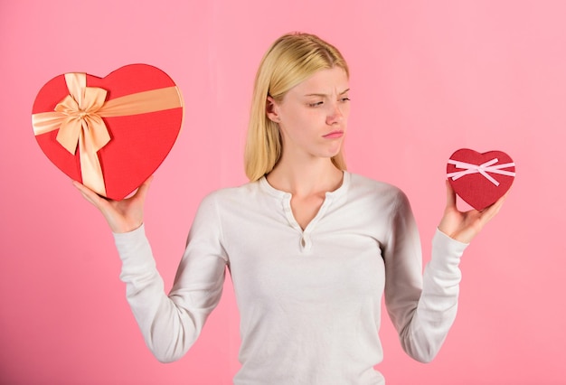 Maakt de maat echt uit Vrouw houdt grote en kleine hartvormige geschenkdozen vast Welke ze het liefste heeft Meisje bepaalt welk cadeau ze leuker vindt Grote verrassing en klein cadeautje Maak een keuze Romantisch cadeau voor haar