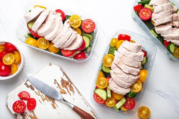 Foto maaltijd prep lunchboxen containers met kip en salade bovenaanzicht