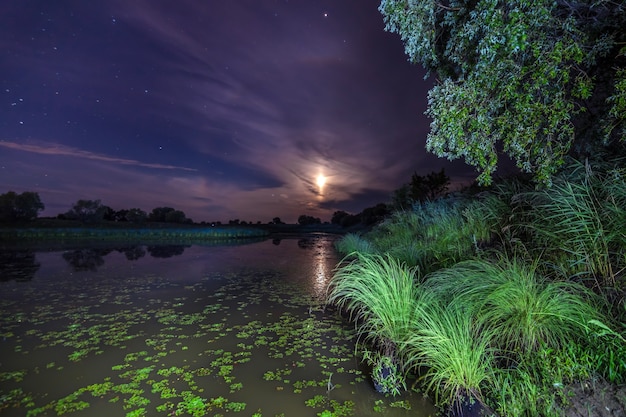 Foto maan boven een meer in de nacht