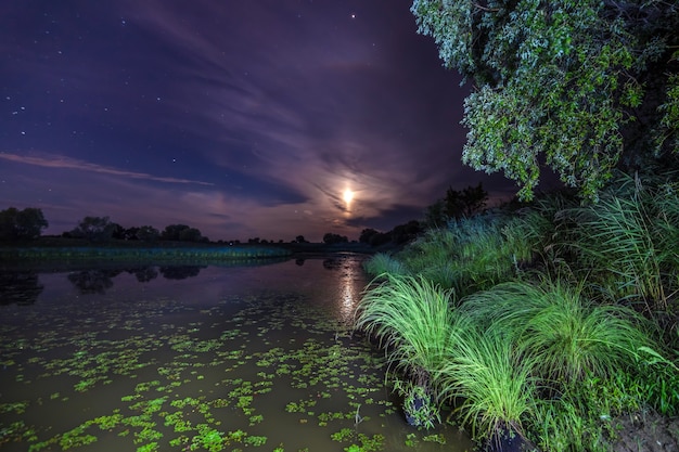 Maan boven een meer in de nacht