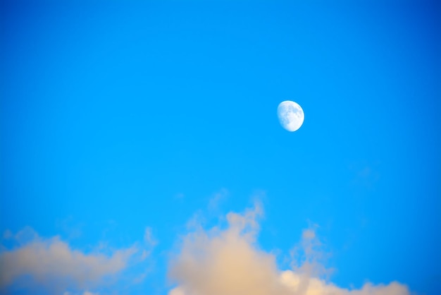 Maan in een blauwe lucht met wolken