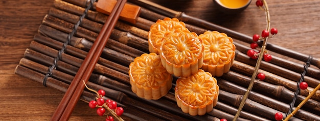 Maancake Mooncake-tafelinstelling - Rond gevormd Chinees traditioneel gebak met theekopjes op houten achtergrond, Mid-Autumn Festival-concept, close-up.