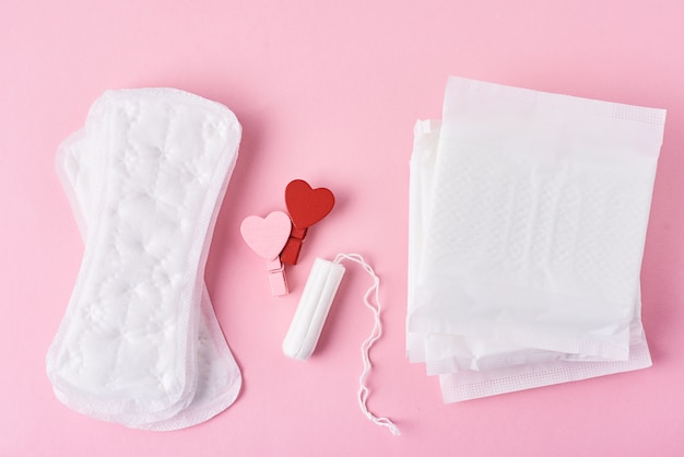 Foto maandverband, menstruatietampon en houten rood hart