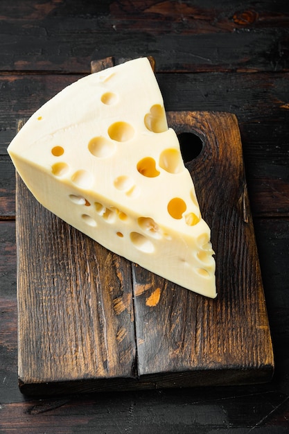 Maasdam cheese set on old dark wooden table