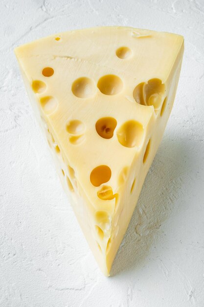 Maasdam cheese on white stone surface