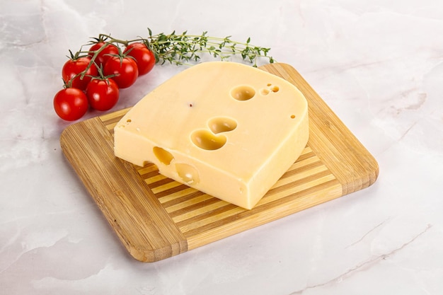 Maasdam cheese with hole brick over board