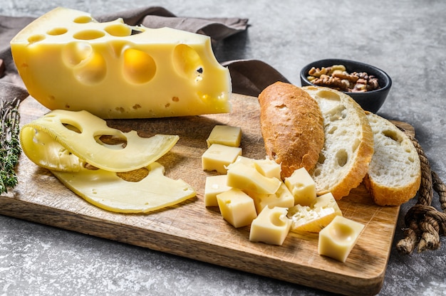 Maasdam cheese with walnut and thyme. Gray background. Top view