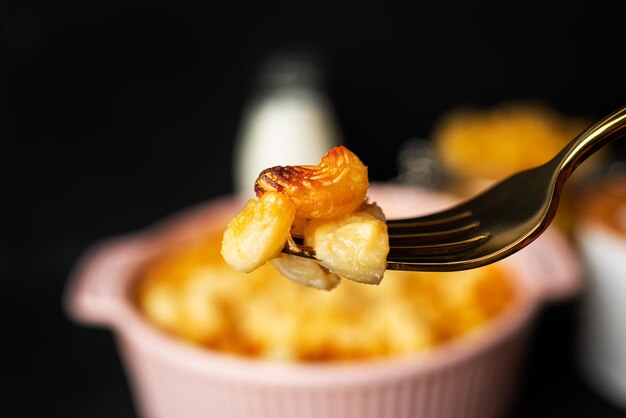 Mac and cheese, american style macaroni pasta in cheesy sauce on dark background. High quality photo