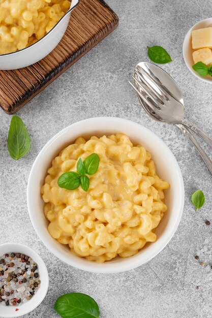 Mac en kaas in een witte schaal met verse basilicum op de top Amerikaanse keuken comfortfood Kopieer ruimte