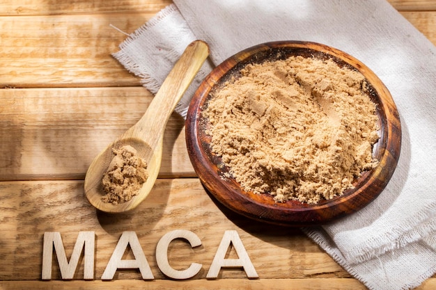 テーブルの上の木製のボウルに入ったマカ パウダー ペルー産の栄養物質