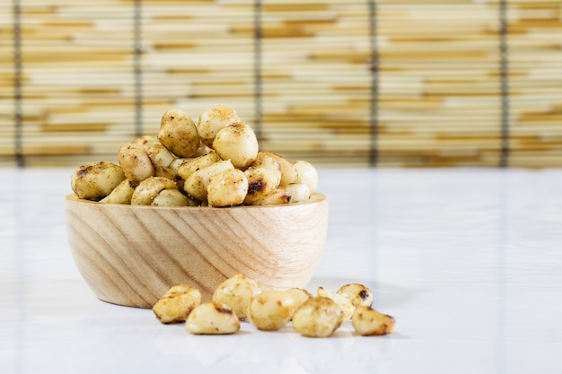 Macadamia gebakken met gezouten in houten kom op witte tafel