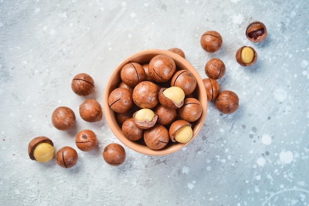 Macadamia nut Macadamia nuts in a shell in a bowl On a stone background Macadamia nuts are rich in various trace elements and vitamins