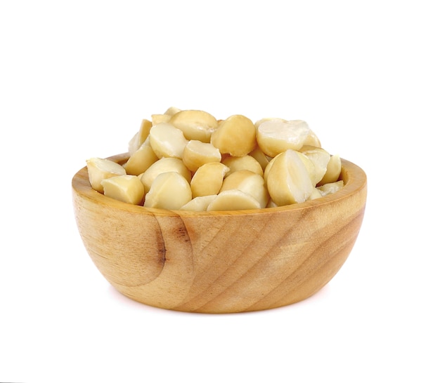 Noce di macadamia in ciotola di legno isolare su sfondo bianco