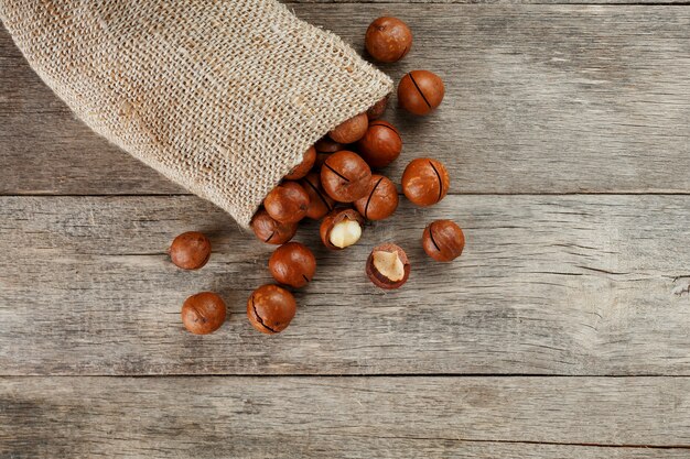 Macadamia nut on a wooden table in a bag