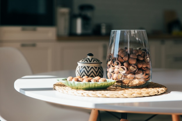 Noci di macadamia si trovano in una ciotola in cucina, luce del mattino duro