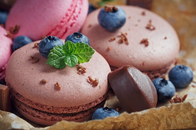 Macaron met verse bosbessen en chocolade op rustieke houten tafel