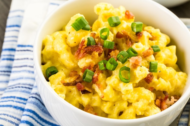 macaroni and cheese garnished with bacon bits and chives.