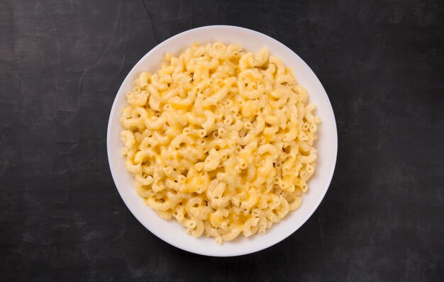 Macaroni and cheese on a white plate on a black background American mac and cheese