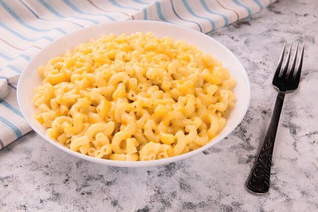 Macaroni and cheese on a white plate on a gray background